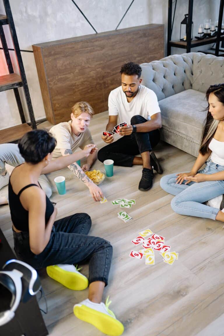 Partygäste spielen ein Trinkspiel mit UNO-Karten