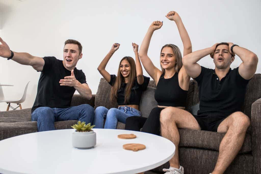 Freunde spielen zusammen ein Fussballtrinkspiel und freuen sich